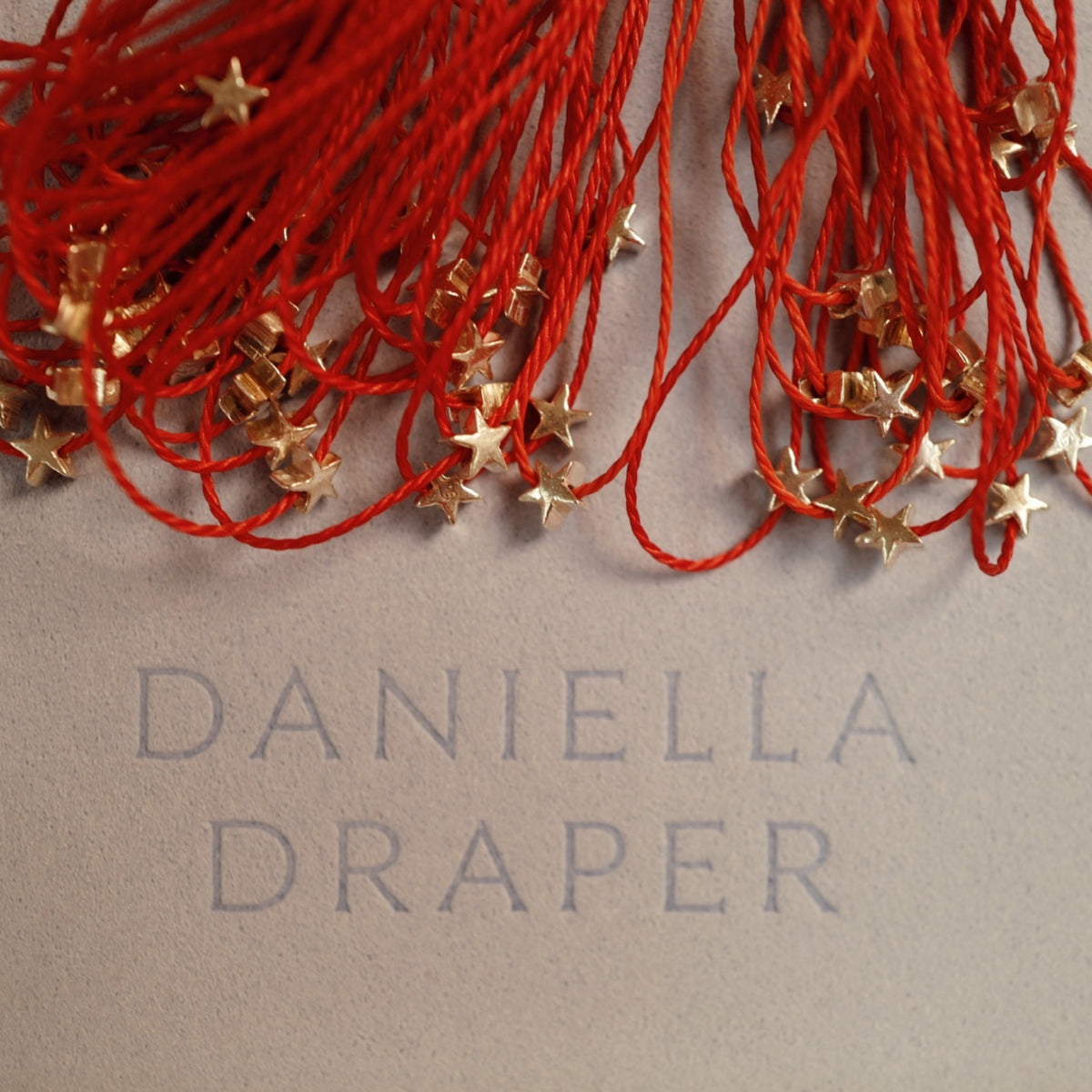 [winter] [badge Product Shown: Gold Wishing Star Bracelet with Red Cord]