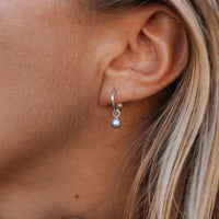 [modelwears Silver Tiny Cupid Hoops with Silver Mini Petrol Pearls]